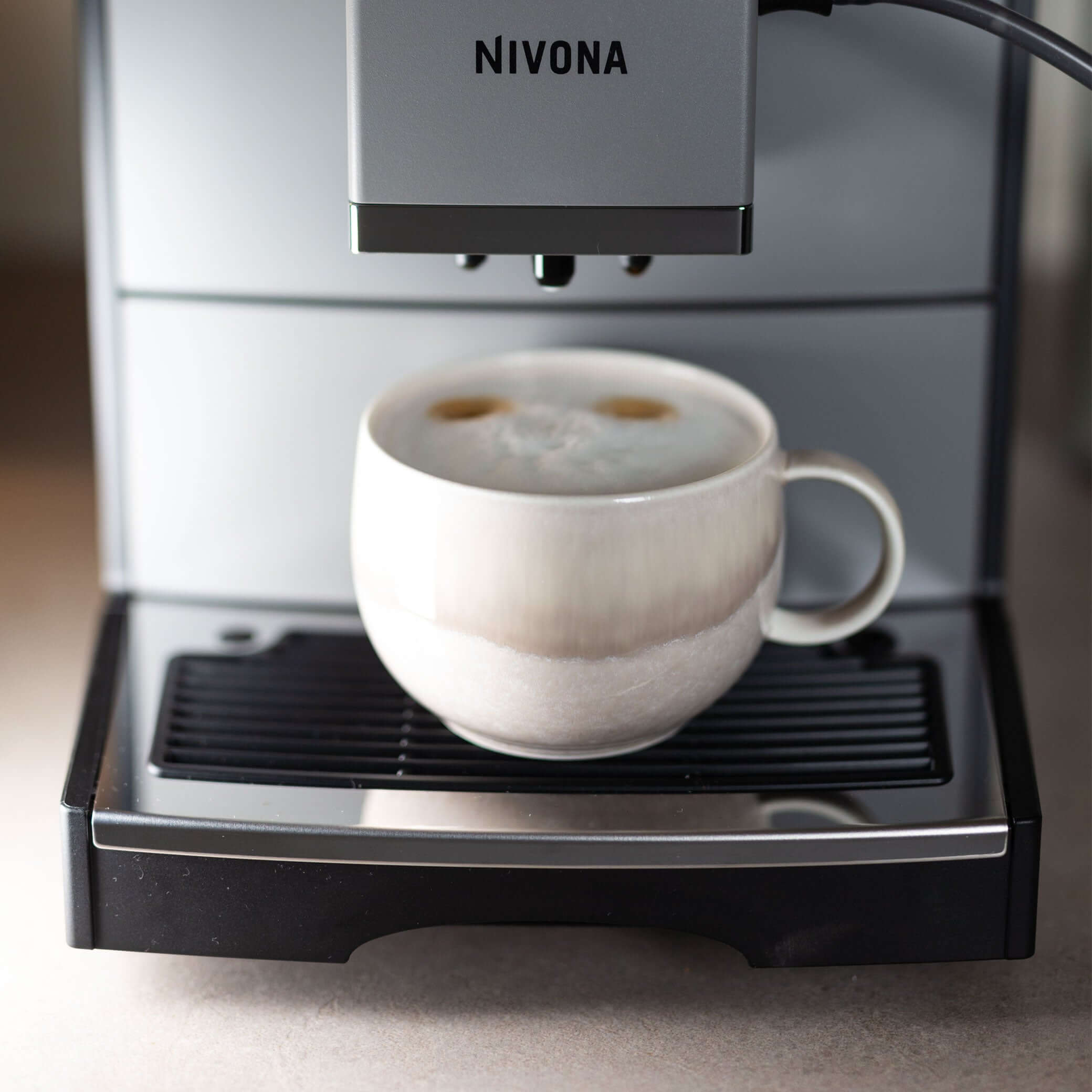 NICR 793 CafeRomatica Fully Automatic Espresso Machine brewing a milky coffee in a cup.