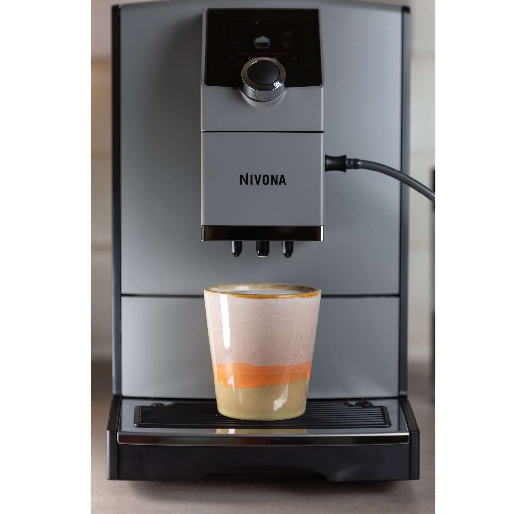 NICR 793 CafeRomatica Fully Automatic Espresso Machine brewing a cappuccino into a colorful mug.